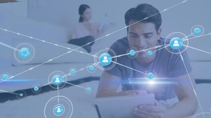 Poster - Animation of network of digital icons and light spot over caucasian man using digital tablet at home