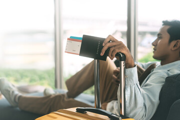 Wall Mural - Traveler asian man arm holding luggage handle passport and reservation airplane ticket