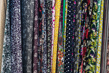 Large Rows Of Pieces Of Fabric Made Of Cotton, Polyester, And Other Materials In Different Colors And Prints Of Clothing, Soft Focus
