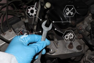 Wall Mural - Automobile mechanic repairman hands repairing a car engine automotive workshop with a wrench