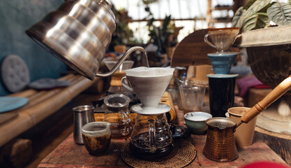 Wall Mural - Man pouring hot water on ground coffee with paper filter to making a drip coffee