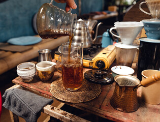 Wall Mural - Man pouring hot water on ground coffee with paper filter to making a drip coffee