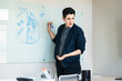 © Cavan Images - Confident young businessman discussing over diagram in board room at office