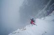 © Cavan Images - Ice climber climbing steep ice wall in winter