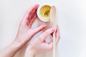 Natural organic salve (balm, cream) in hands with wooden spoon