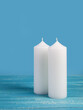 Two white candles on a blue background