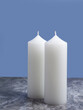Two white candles on a blue background