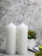 Two white candles on a dark marble table