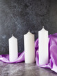 Decorative candles on lilac satin with flowers and beads