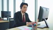 © M Stocker - Young Asian male customer support phone operator with headset working in call center