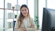 © M Stocker - Young Asian woman customer support phone operator with headset looking at camera and arms crossed