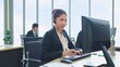 © M Stocker - Young Asian woman customer support phone operator with headset working in call center