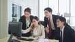 © M Stocker - A group of young business people discuss and using computer while working together in a modern workplace