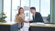 © M Stocker - Two asian businesspeople sitting and talking about their business in modern corporate office