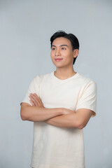 Wall Mural - Handsome young man smiling with arms crossed on white background