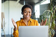 © Prostock-studio - Cheerful black female manager making video call wearing headset and talking to laptop webcam sitting in office