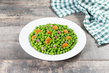 Wall Mural - Green peas with serrano ham and carrot on wooden table.