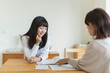© amanaimages - テーブルで資料を見ながら会話をする母娘
