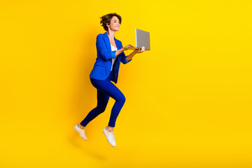 Wall Mural - Full length photo of cute positive lady dressed blue blazer jumping high working gadget empty space isolated yellow color background