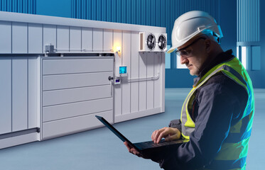 Wall Mural - Engineer man near freezer. Worker controls warehouse refrigerator. Warehouse employee with laptop. Industrial refrigeration equipment. Container refrigerator for frozen food. Man control refrigerator