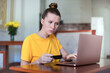 © Евгений Шемякин - Serious woman entering information from credit bank card on laptop at home, online shopping