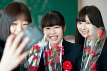 教室で自撮りをする女子学生