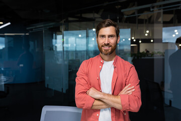 Portrait of successful businessman owner of small business, mature man in casual red shirt standing smiling and looking at camera with crossed arms.