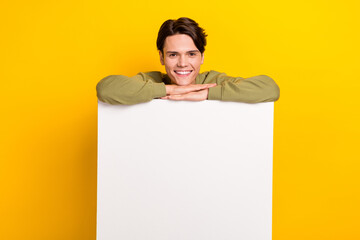 Wall Mural - Photo of positive successful man wear khaki clothes stand behind board empty space promote store isolated on yellow color background