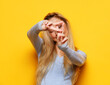 © Raisa Kanareva - lifestyle, emotion and young people concept: Young woman smiling and show v-sign over yellow background