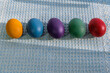 colored easter eggs laying on blue cloth 