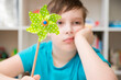 A boy plays with a windmill at home. Global autism day commemoration theme. 