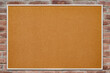© mitand73 - An empty cork board is hanging on a brick wall. Copy space.