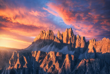 Wall Mural - Rocky mountains at amazing colorful sunset in summer in Dolomites, Italy. Mountain ridges and beautiful sky with pink, red and ornage clouds and sunlight in spring. Landscape with rocks, mountain peak