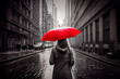 Retro Bild mit Colorkey-Effekt:Frau mit roten Regenschirm in einer verregneten schwarz weiß Stadt - Generative Ai