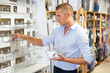 © JackF - Positive european man customer visiting store of household goods in search of new bathroom accessories