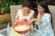 Hispanic women cooking a traditional Colombian and Mexican dish made with corn dough.