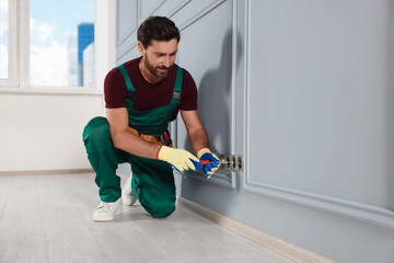 Canvas Print - Electrician with screwdriver repairing power sockets indoors