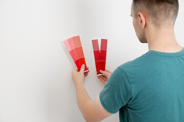 Poster - Man with palette choosing color for painting wall indoors. Interior design