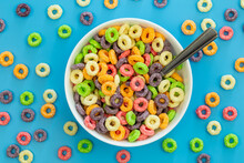 Colored Breakfast Cereal In A Bowl On A Blue Background, Flat Lay, Children's Healthy Breakfast, Close Up.