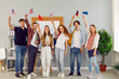 © Studio Romantic - Young people who take part in university exchange program meet and make friends of different nationalities. Happy cheerful joyful international students standing together, holding up flags and smiling