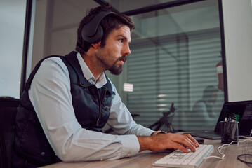 Poster - Headphones, programmer keyboard and man typing, coding or programming online at night. Information technology, computer and male employee or coder working on software while streaming music or radio.