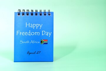 Wall Mural - Happy Freedom Day South Africa greeting reminder on blue desk calendar with flag icon. National day celebration concept.