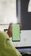 Poster - Vertical video: Female manager looking at greenscreen display in office, working with isolated mockup template on mobile phone. Young employee using blank copyspace mockup in coworking space.