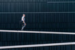 © Cavan Images - Mature bearded businessman walking in the city on a wall
