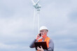© Cavan Images - older energy engineer in front of a wind turbine