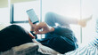 © Cavan Images - Young man relaxing listening the music from mobile phone.