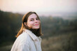 © Cavan Images - Portrait of a beautiful young woman in warm clothes during sunset