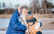 © Cavan Images - grandmother comforting her grandson whilst playing outside in winter