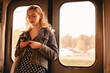 © Cavan Images - Young woman using smart phone while traveling in subway train