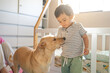 © Cavan Images - Little latin boy eating cookies accompanied by his mixed breed puppy